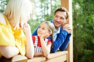Family with young child enjoying their new front porch in rural Ontario, considering first-time homebuyer mortgage options - Mortgage Scout