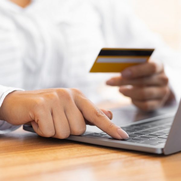 Woman using laptop and credit card for online payment at home in Ontario - Mortgage Scout